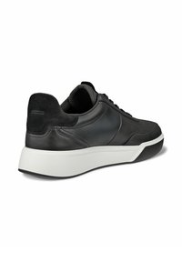 Schwarze Low-Top-Sneaker mit Wildleder-Ferse, Leder-Obermaterial, gepolsterter Mesh-Kragen, dicker weißer Sohle und schwarzem Gummisohle, schräger Blick von der rechten Seite.