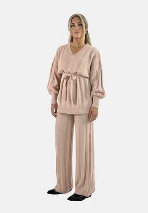 Conjunto de punto de dos piezas en rosa suave. Parte superior de manga larga y escote en V con cinturón de lazo, combinado con pantalones de pierna ancha y canalé. Tejido texturizado.