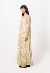 Blumiges Maxikleid in Pastellfarben mit einem fließenden Design. Es hat dünne Spaghettiträger und einen leichten Stoff mit filigranen Mustern.