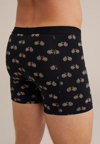 Vyriški juodi bokseriai su daugiaspalviu dviratį vaizduojančiu printu. Pagaminti iš minkštos medžiagos, turi patogią juosmens juostą ir plokščias siūles.