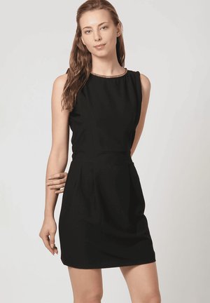 Vestido negro sin mangas con un corsé ajustado, falda plisada y un sutil borde metálico alrededor del escote, hecho de una tela suave.