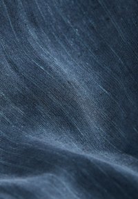Dark blue fabric with a fine, textured surface. Subtle variations in shade create a striated pattern. Soft, lightweight material.