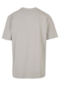 Lys grå T-shirt med korte ærmer set fra ryggen, med rund halsudskæring og synlige sting på ærmerne og nederste kant.