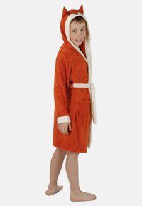Orangene Baumwollbademantel mit einem weißen Fleecefutter, das ein Fuchsdesign mit Ohren, einem Gürtel und einer Vordertasche zeigt, steht barfuß.