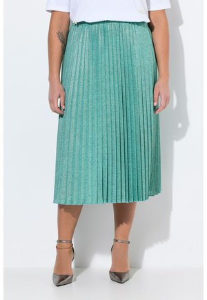 Falda midi plisada en verde azulado con tejido texturizado. Presenta una cinturilla suave y un brillo sutil, combinada con zapatos de tacón alto plateados.