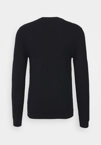 Svart långärmad tröja med texturerat stickat mönster, med rund halsringning och ribbstickade mudd och nederkant. Bakvy visar ett enkelt mönster.