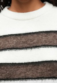 Gestrickter Pullover mit weißem Grund, der braune und schwarze horizontale Streifen aufweist. Weiche Textur mit einem gerippten Kragen.