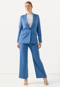 Ljusblå skräddarsydd kavaj med matchande vida byxor; har en enkel knapp, två framfickor och en figursydd silhuett.