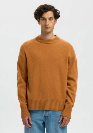 Oranger gestrickter Pullover mit geripptem Rundhalsausschnitt, langen Ärmeln und einer strukturierten Stoffqualität. Trägt man zu hellblauen Jeans.