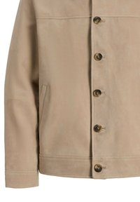 Veste en daim beige à manches longues, boutons sur le devant et une poche passepoilée latérale du côté gauche du vêtement.