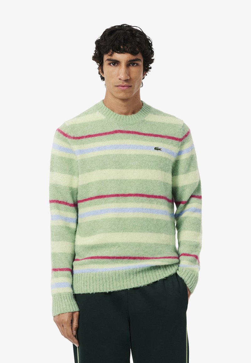 Maglione a righe verde chiaro con linee orizzontali pastello in blu, rosa e bianco. Realizzato in tessuto testurizzato con bordi a costine.