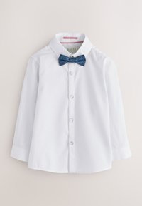 Chemise blanche à manches longues boutonnée, col pointu et nœud papillon bleu à motifs.