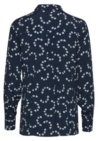Marineblauw shirt met een bloemenpatroon, lange mouwen en knoopmanchetten. Kenmerkt zich door een rugplooi en kraagdetails. Glad stofgevoel.