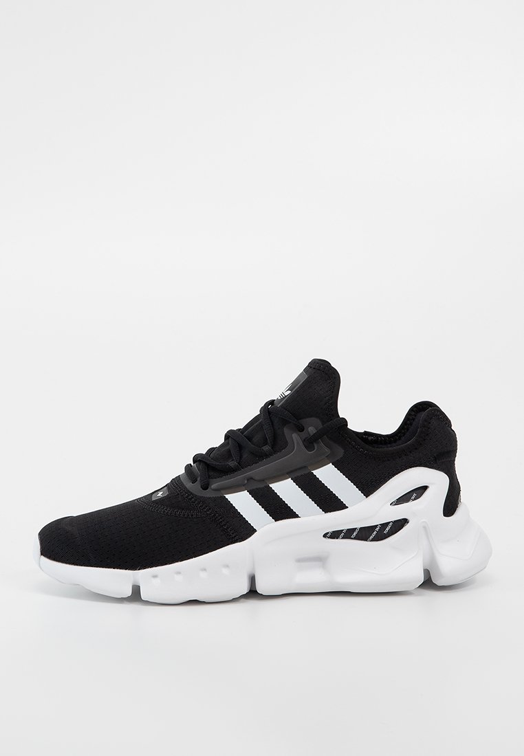 Svart atletisk sneakersko med vit sula och tre vita ränder på sidan, med en modern, kraftig design och ovandel i mesh.