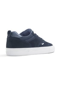 Tamnoplave suede tenisice s bijelim gumene đon, s teksturiranim gornjim dijelom, prošivenim detaljima i dizajnom s okruglim vrhom. Jednostavno vezivanje.