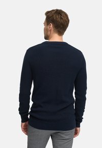 Marineblauer Strickpullover mit strukturiertem Muster, Rundhalsausschnitt und langen Ärmeln. Glatte Oberfläche und gerippte Bündchen sowie Saum.