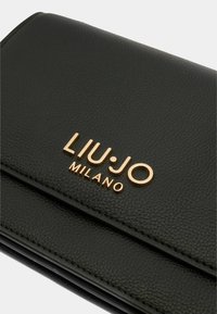 Portafoglio in pelle nera con finitura texturizzata, logo in tono oro impresso sul davanti e elementi di design eleganti e minimalisti.