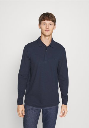 Polo-shirt à manches longues bleu marine en coton, avec un col classique, trois boutons, et un petit logo brodé sur la poitrine.