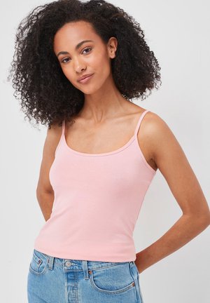 Lys rosa tætsiddende tanktop med smalle stropper, lavet af blød bomuld, med en rund udskæring og en glat overflade, kombineret med blå denim.