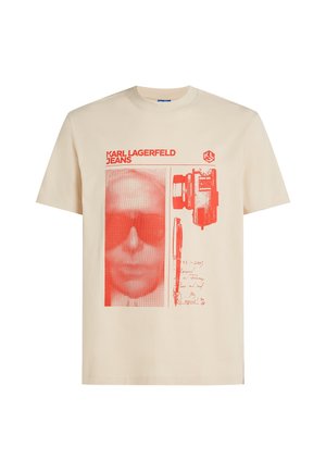 T-shirt beige à manches courtes avec imprimé graphique rouge représentant un visage pixélisé, un appareil photo, un stylo et le texte "KARL LAGERFELD JEANS".