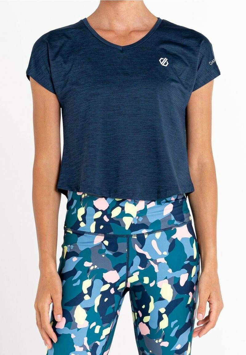 Top atletico blu navy a maniche corte con scollo a V. Abbinato a leggings multicolori e stampati con forme blu, rosa e gialle.