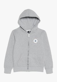 Grijze rits hoodie van zachte katoen, met een logo patch aan de voorkant, buidelzakken en ribgebreide manchetten en zoom. Capuchon met trekkoord.