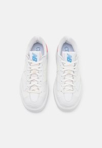 Sneakers bianchi con tomaia in pelle liscia, punta arrotondata e cuciture tonali. Presentano un logo blu sulla linguetta e dettagli rossi sul tallone.