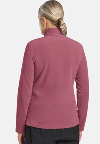 Pullover in pile di colore malva, con colletto alto, maniche lunghe e una texture liscia. Design semplice con taglio dritto e nessun chiusura visibile.