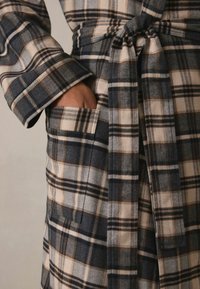 Kariertes Morgenmantel in Navy-, Beige- und Brauntönen; weiches Flanellmaterial; mit Bindegürtel und Seitentaschen; sichtbares Karomuster.