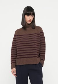 Maglione a collo alto a righe marroni con una vestibilità morbida. Presenta righe orizzontali in tonalità più scure, bordo a costine e una texture morbida.
