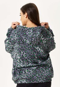 Hooded sweatshirt in grey with a vibrant green and black leopard print. Soft texture, loose fit, and adjustable drawstring hood.