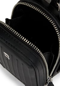 Schwarze Lederhandtasche mit texturiertem Design, silbernen Reißverschlüssen und einem Hauptfach mit Reißverschluss. Kompakt und schlank mit sichtbaren Nähdetails.
