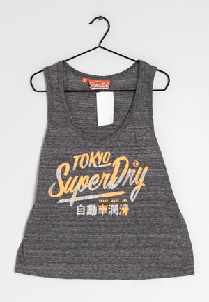 Szary bezrękawnik z dekoltem w kształcie litery U, z nadrukiem logo w kolorze pomarańczowym i srebrnym. Materiał wydaje się miękki i o teksturowanej powierzchni.