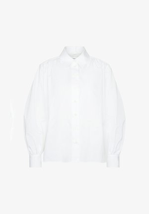 Blusa bianca a maniche lunghe con chiusura frontale a bottoni, colletto appuntito, spalle arricciate e polsini aderenti.