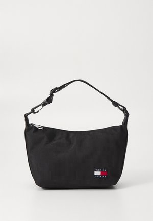Sort lille Tommy Jeans skuldertaske med ét lynlåskompartement og justerbar rem på ensfarvet baggrund.