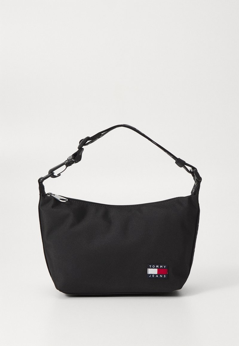 Petit sac d'épaule noir Tommy Jeans avec un compartiment unique zippé et une sangle ajustable sur un fond uni.
