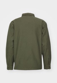 Olive green cotton jacket, featuring a collared neckline, long sleeves with buttoned cuffs, and a relaxed fit with a smooth texture.