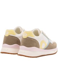 Sneakers met een witte synthetische bovenkant, tan suède accenten, lichtblauwe en gele details, een roze middenzool en een getextureerde rubberen buitenzool.