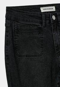 Crne traperice s srednjim strukom, s stražnjim džepom, vidljivim šavovima i oznakom "SOFIE SCHNOOR."