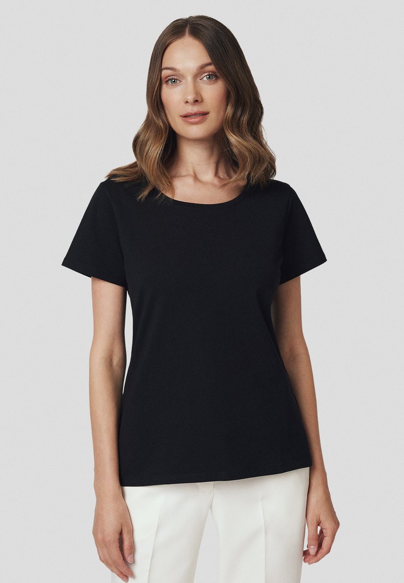 Czarna koszulka z krótkim rękawem i okrągłym dekoltem. Wykonana z miękkiego materiału, o luźnym kroju i gładkiej teksturze. Prosty, minimalistyczny design.