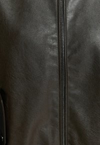 Czarna skórzana kurtka z centralnym zamkiem, gładką fakturą oraz boczną kieszenią o subtelnym matowym wykończeniu.