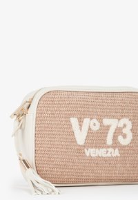 Pochette in materiale intrecciato simile a paglia con dettagli in finta pelle color crema, accessori dorati e tassel decorativo; presenta ricamo "V°73 VENEZIA".