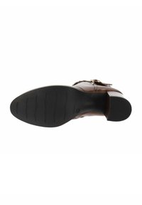 Stivaletto in pelle marrone con suola in gomma nera e tacco basso a blocco, dettaglio con cinturino e fibbia sulla parte superiore.
