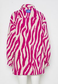 Fleecejacka med rosa och vita zebra-ränder, långa ärmar, krage och en blå märkesetikett på baksidan.