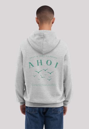 Grauer Hoodie mit einem Rückenprint, der den Text "AHOI", stilisierte Vögel und ein beschreibendes Zitat zeigt. Hergestellt aus weichem Stoff mit einem lockeren Schnitt.