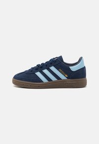 Navy suede sneaker with light blue stripes and gold lettering. Features a brown rubber sole and rounded toe design. Classic athletic style.