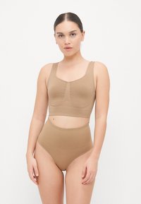 Set composto da reggiseno e mutandine a vita alta in un tessuto liscio e elasticizzato. Entrambi i pezzi sono di un colore marrone chiaro con dettagli delle cuciture sottili.