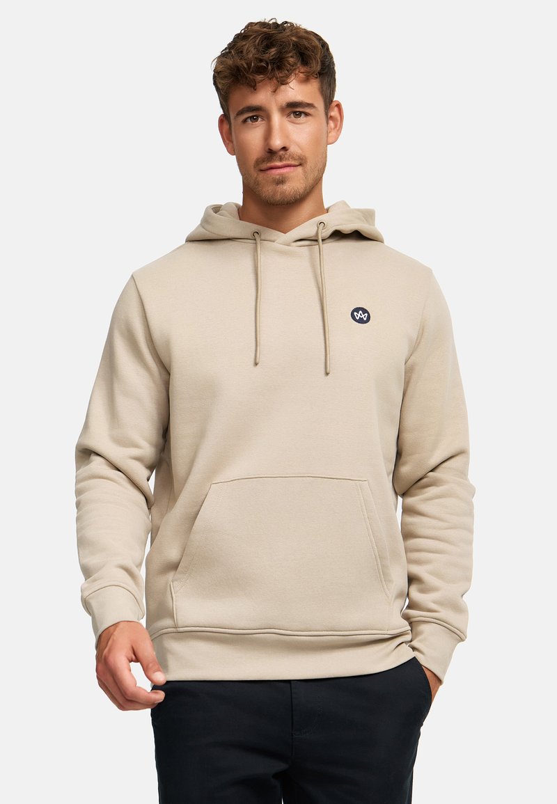 Beige mikina s kapucí a šňůrkami, přední kapsou a malým logem. Měkká textura, neutrální barva a žebrované manžety a lem.