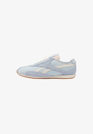 Lage, lichtblauwe en crèmekleurige sneaker met suède en leren panelen en een dunne bruine zool, getoond in zijaanzicht links op witte achtergrond.