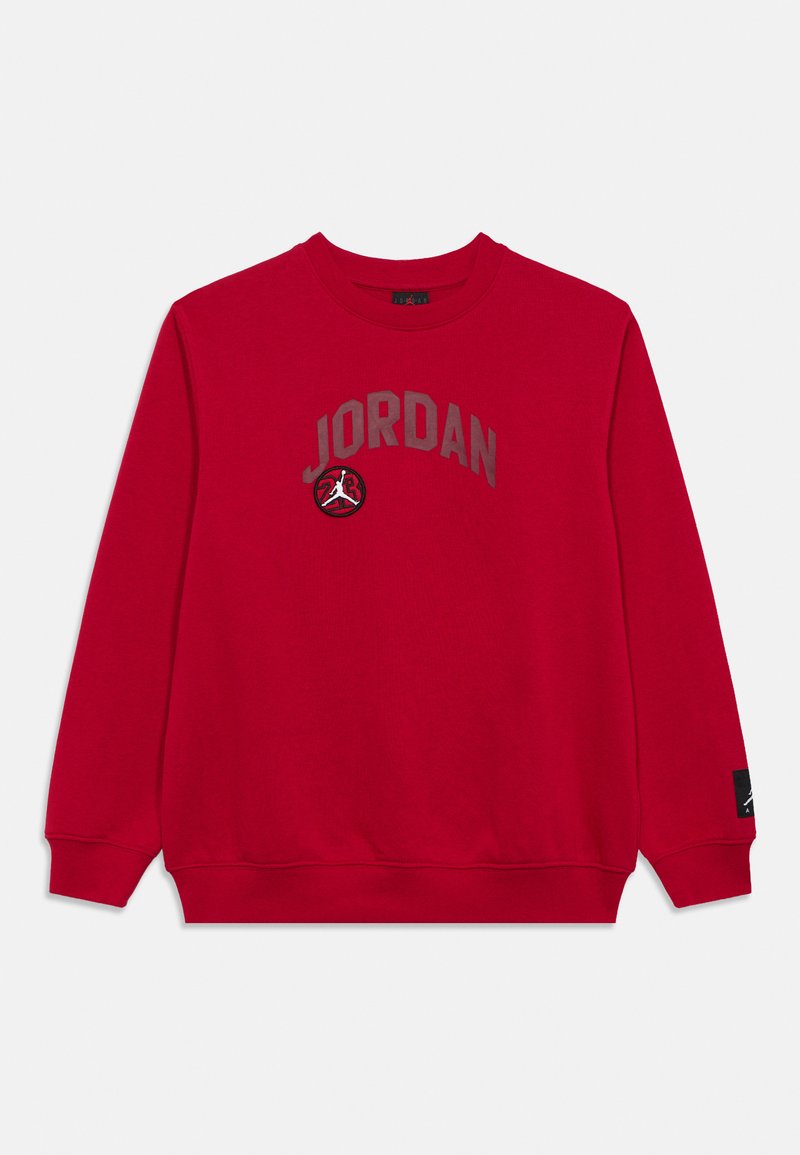 Κόκκινο φούτερ με στρογγυλή λαιμόκοψη και μακριά μανίκια, με την επιγραφή «JORDAN» και λογότυπο μπάσκετ στο στήθος, καθώς και μια μικρή μαύρη ετικέτα λογότυπου στο μανίκι.